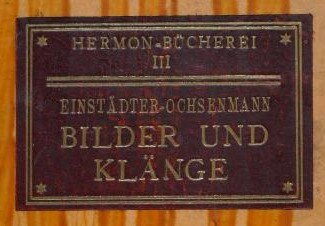 Die Titelseite aus einem der Bücher De Jonges. In einem roten rechteck stehen mit einer gold ähnlichen Schrift: Hermon Bücherei III, Einstädter Ochsenmann- Bilder und Klänge.